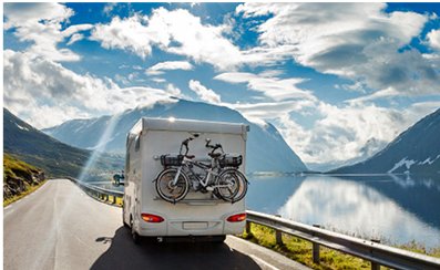 Caravan travelling a fjord road with a bike rack on the back
